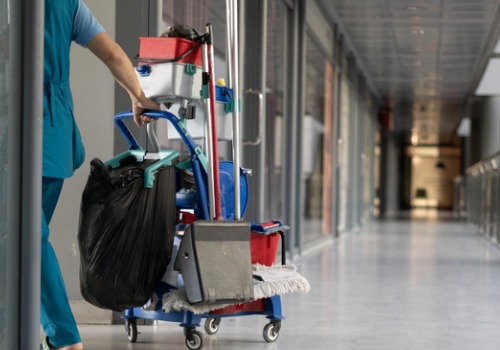 A member of All Window Cleaning Services pulls a cart with cleaning supplies as she offers interior cleaning services