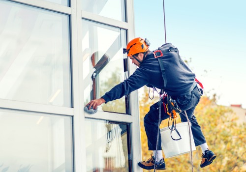 A window washer from All Window Cleaning Services provides exterior cleaning services for a high rise building