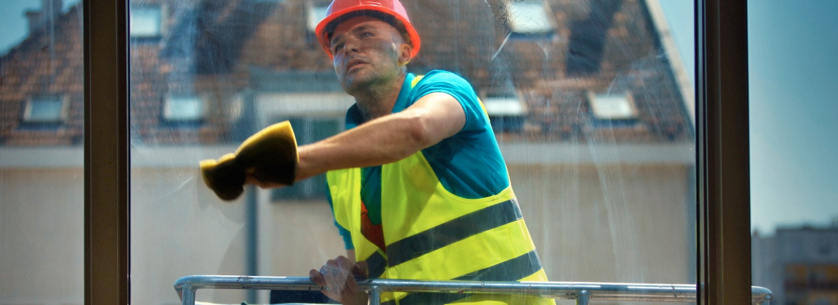A professional window cleaner cleaning the outside of a high-rise building in Iowa