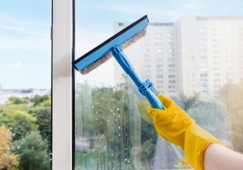 A member of All Window Cleaning Services finishes post-construction window cleaning inside of a new high rise.